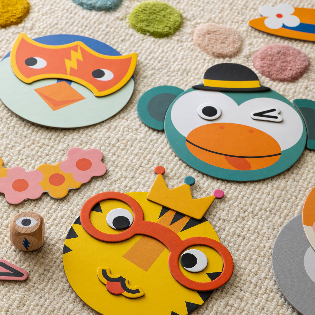 Colorful paper masks and a dice on a textured surface