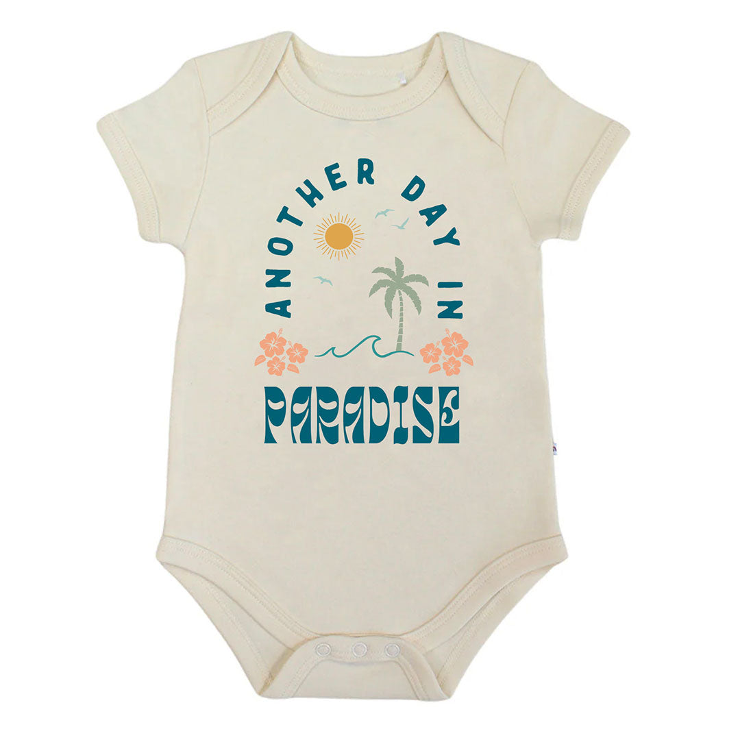 Baby bodysuit with 'Another Day in Paradise' text and graphics on a white background