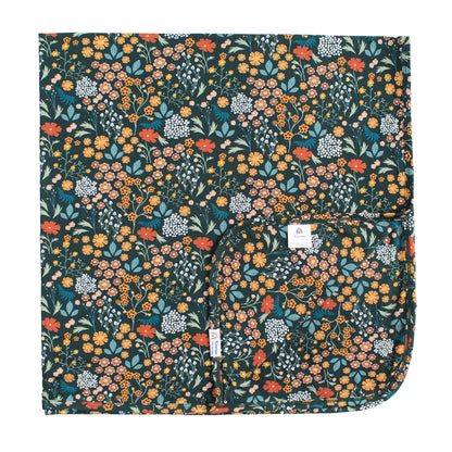 dark green bamboo blanket with floral print on white background. 