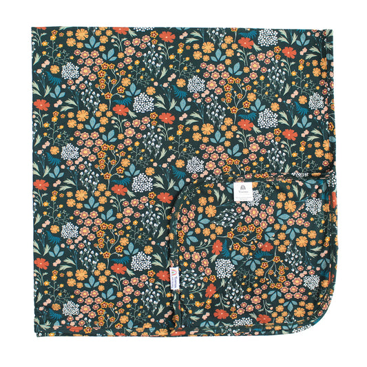 dark green bamboo blanket with floral print on white background. 
