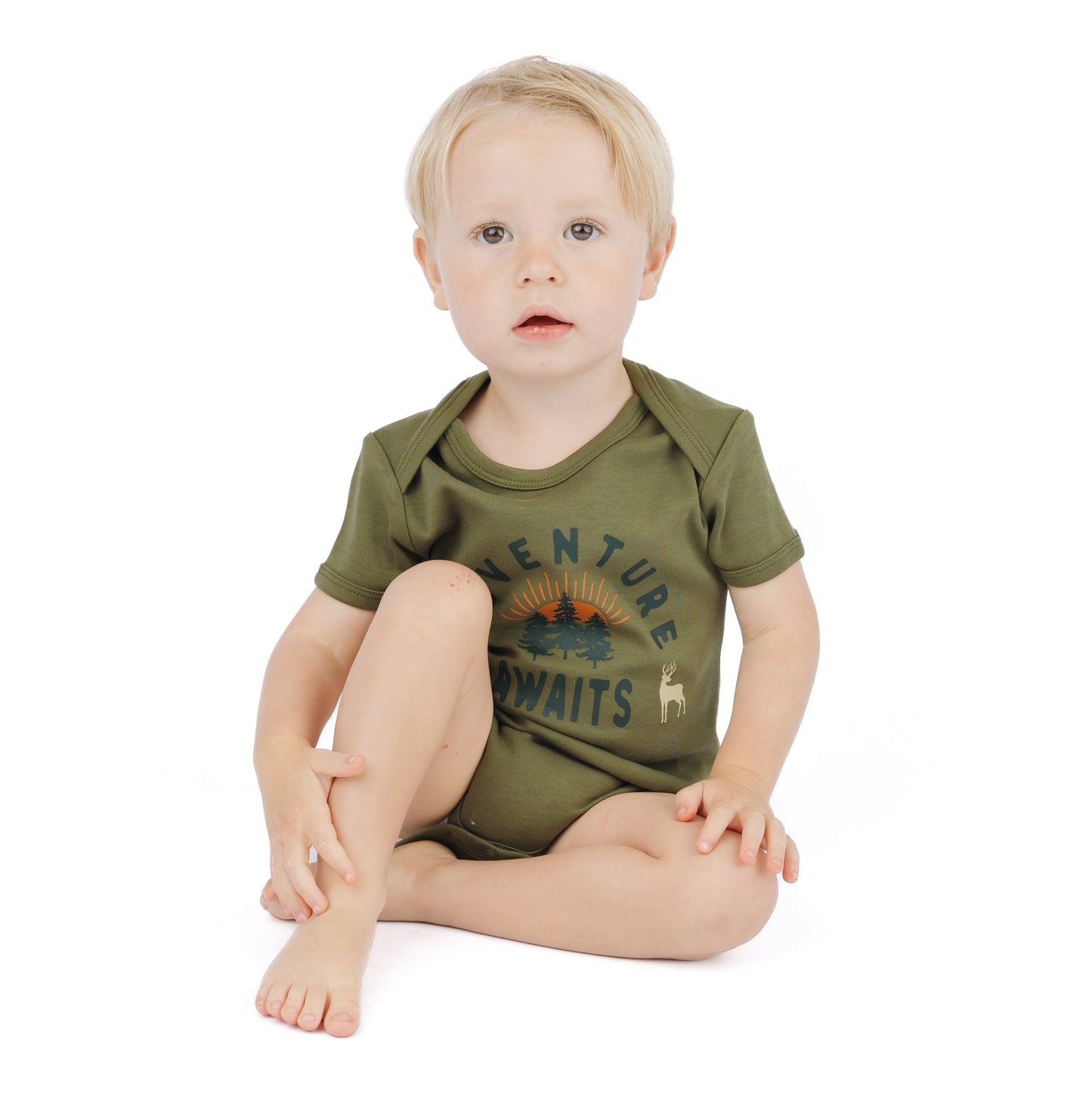 baby wearing forest green onesie with adventure awaits graphic