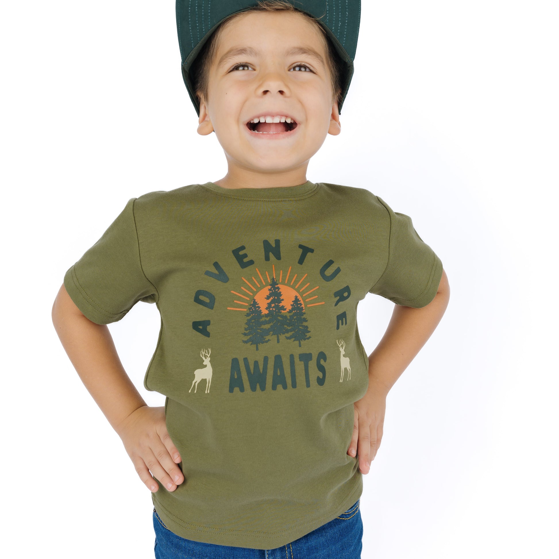 little boy wearing green tee with adventure awaits graphic