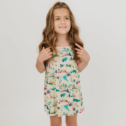 Toddler girl wearing out Emerson and Friends Coral Reef Bamboo Sundress featuring an ocean-inspired print with sharks, sea turtles, and coral, made from ultra-soft and breathable bamboo fabric for a lightweight and comfortable summer outfit.