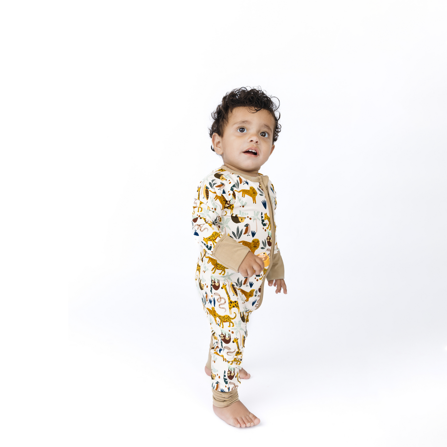 Baby wearing a onesie with animal print on a white background