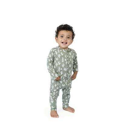 Child wearing a green cactus pajama set with a pattern on a white background