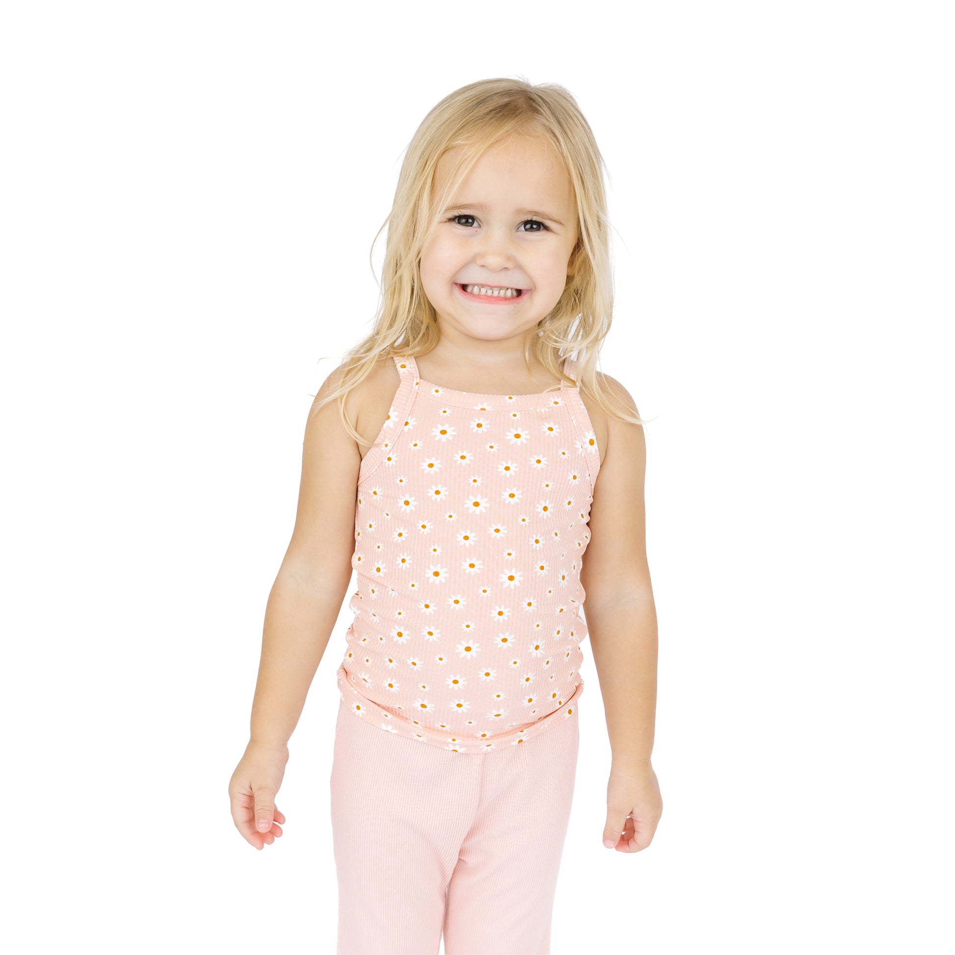 Young girl wearing a pink sleeveless top and pants on a white background