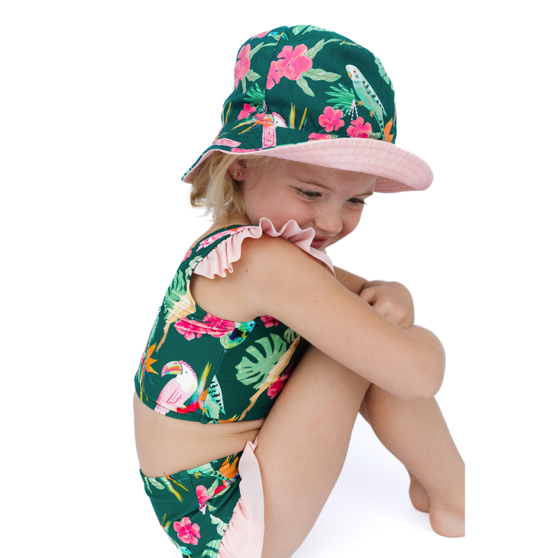 Child wearing a floral swimsuit and hat on a white background