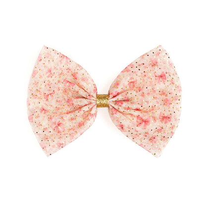 Pink bow with gold center on a white background