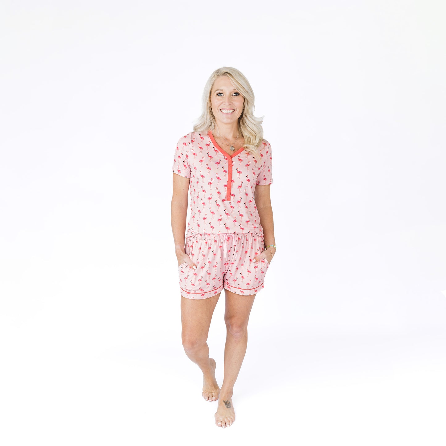 Woman wearing a pink pajama set with a white background