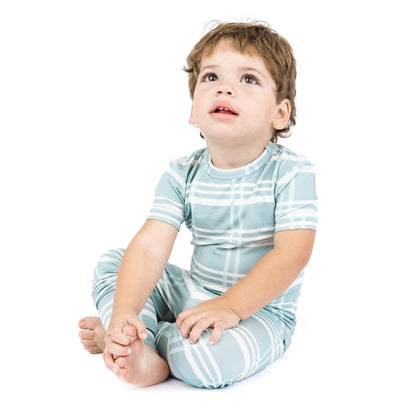 Child wearing a blue and white striped outfit on a white background