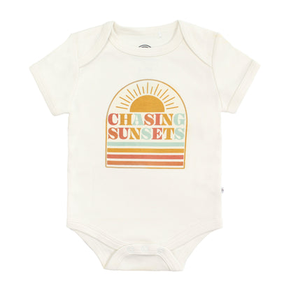 Baby bodysuit with 'Chasing Sunsets' design on a white background