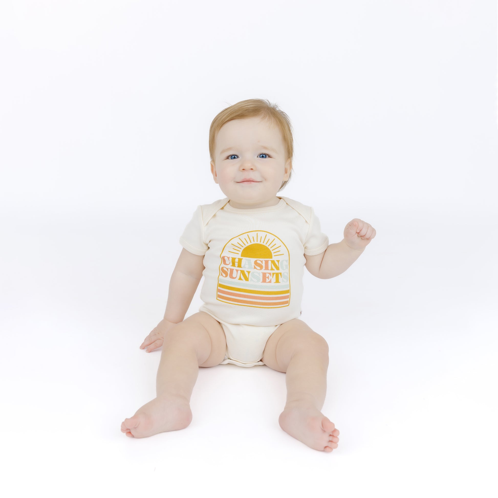 Baby wearing a bodysuit with 'All Sun Sunset' design on a white background