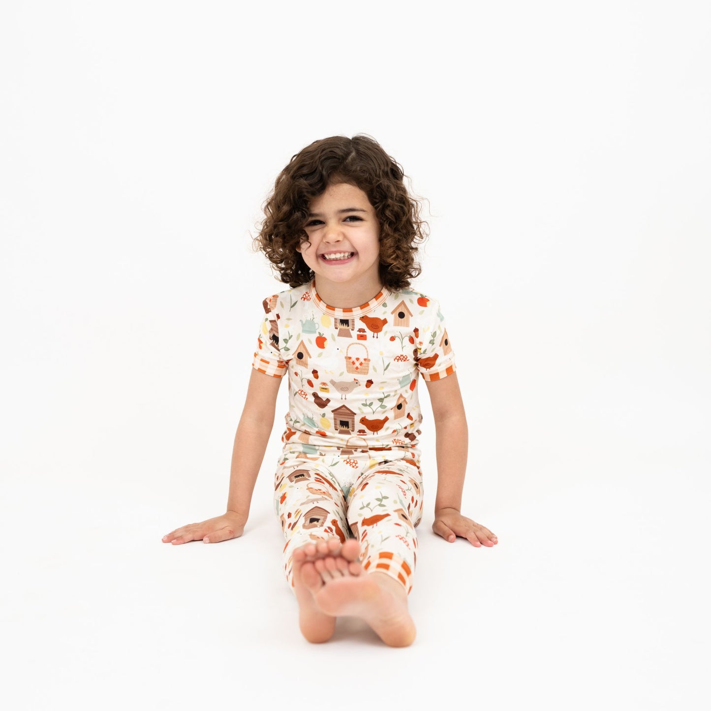 Girl in Cozy Cottage bamboo pajama pants set sitting barefoot in studio.