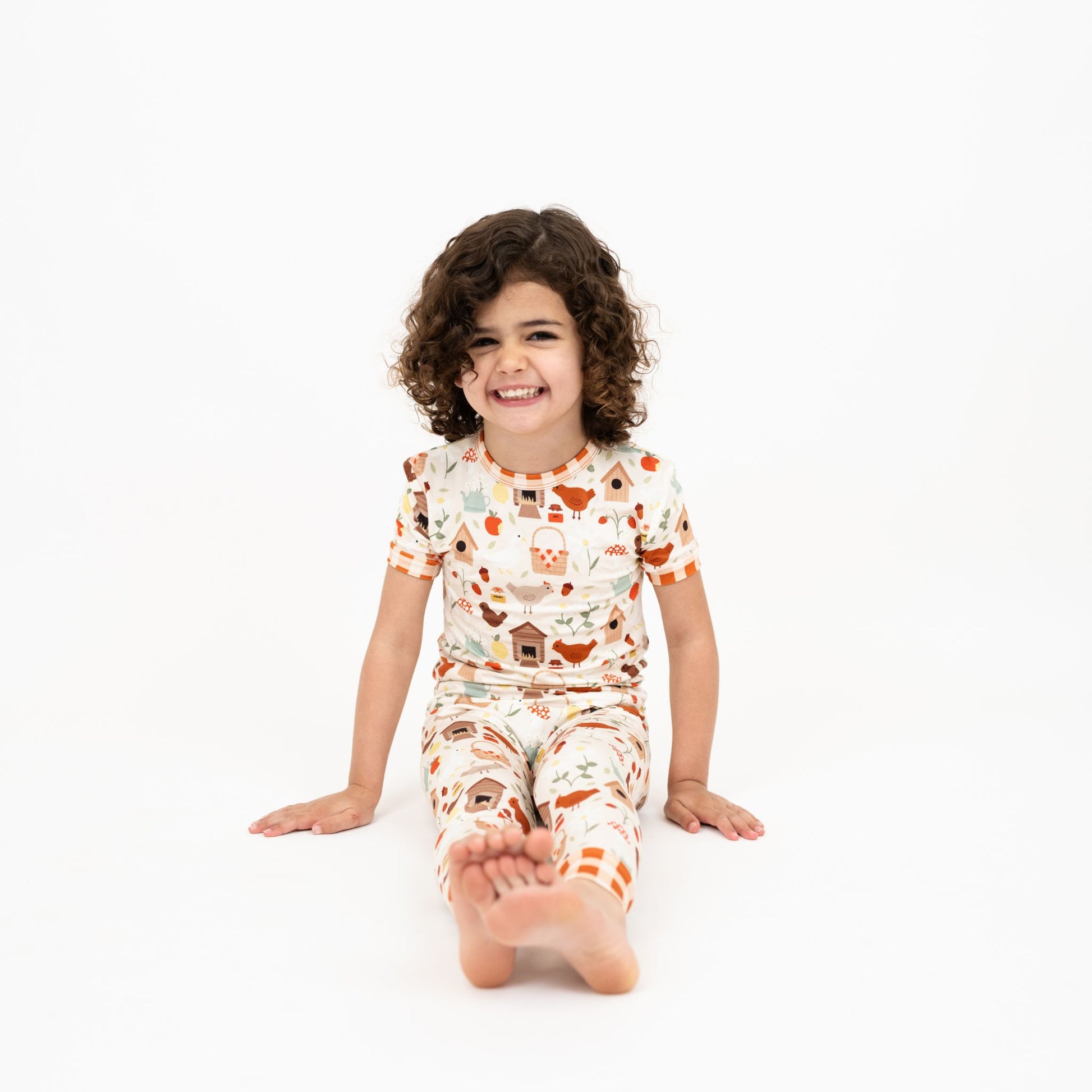 Girl in Cozy Cottage bamboo pajama pants set sitting barefoot in studio.