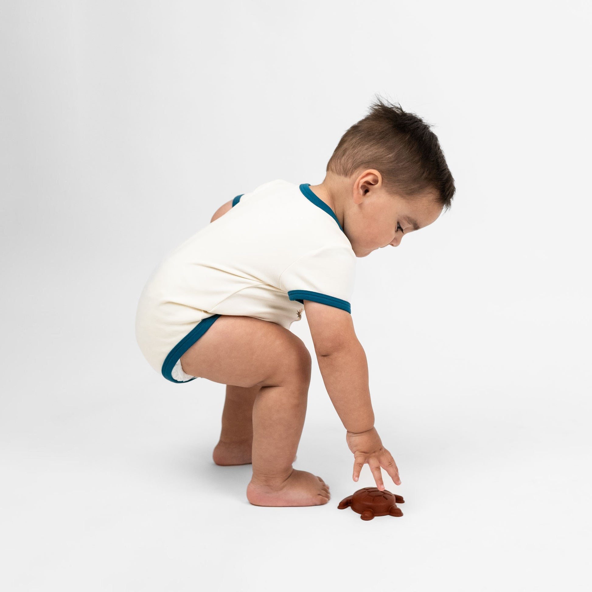 Baby boy wearing our Howdy cotton bodysuit featuring the word "Howdy" in playful, blue letters, perfect for a western outfit.