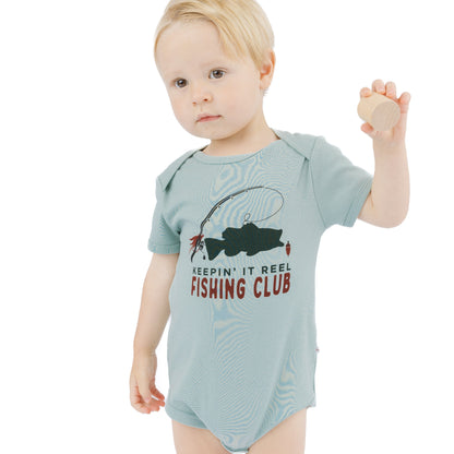 little boy in blue bodysuit with fish print