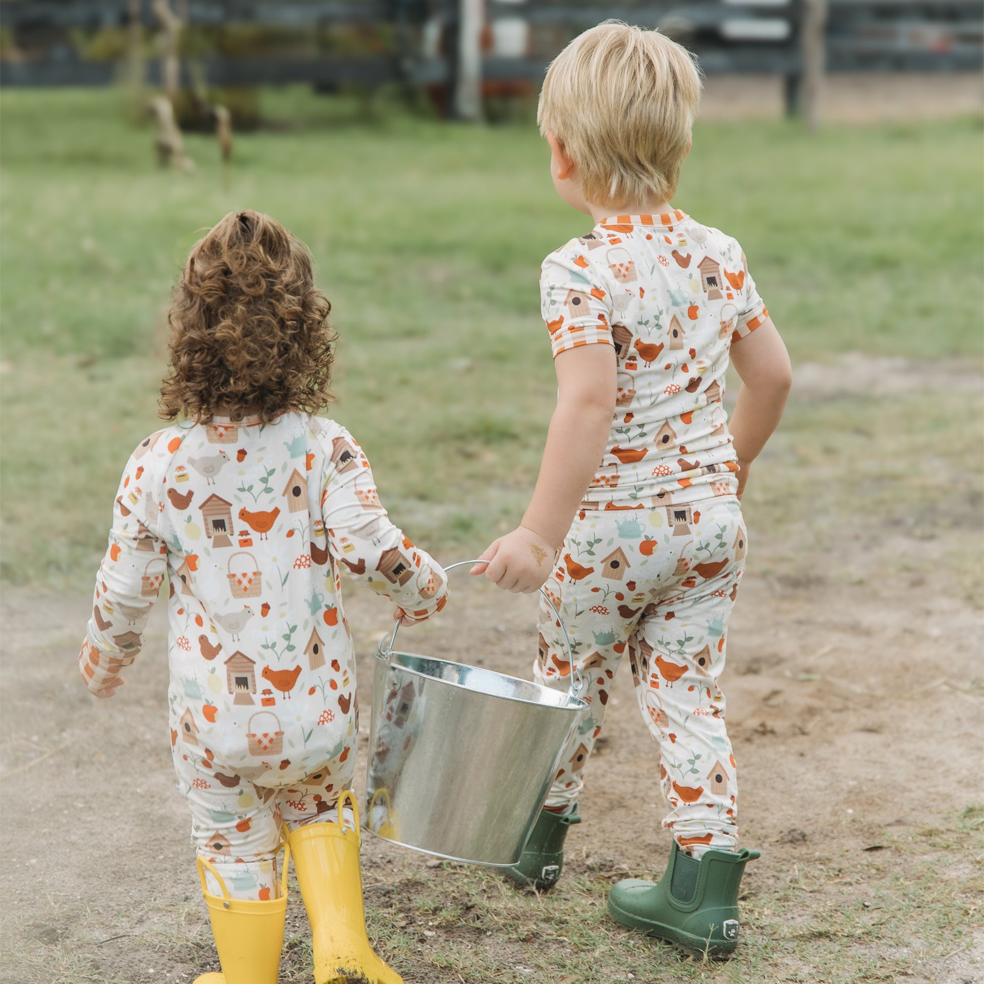 Kids wearing Cozy Cottage bamboo pajama pants set holding a farm bucket outdoors.