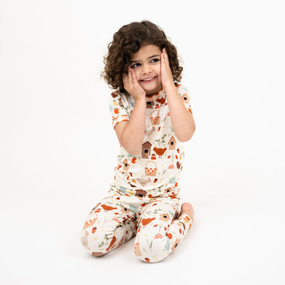 Girl wearing Cozy Cottage bamboo short sleeve pajama pants set sitting with hands on face.