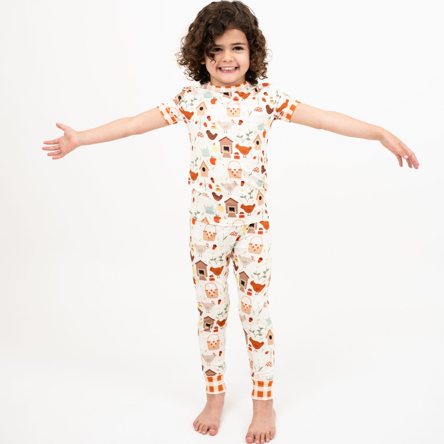 Girl standing with arms open wearing Cozy Cottage bamboo short sleeve kids pajama set.