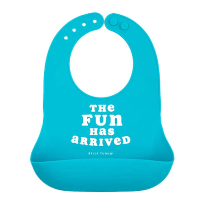 blue silicone baby bib with white writing that says the fun has arrived 