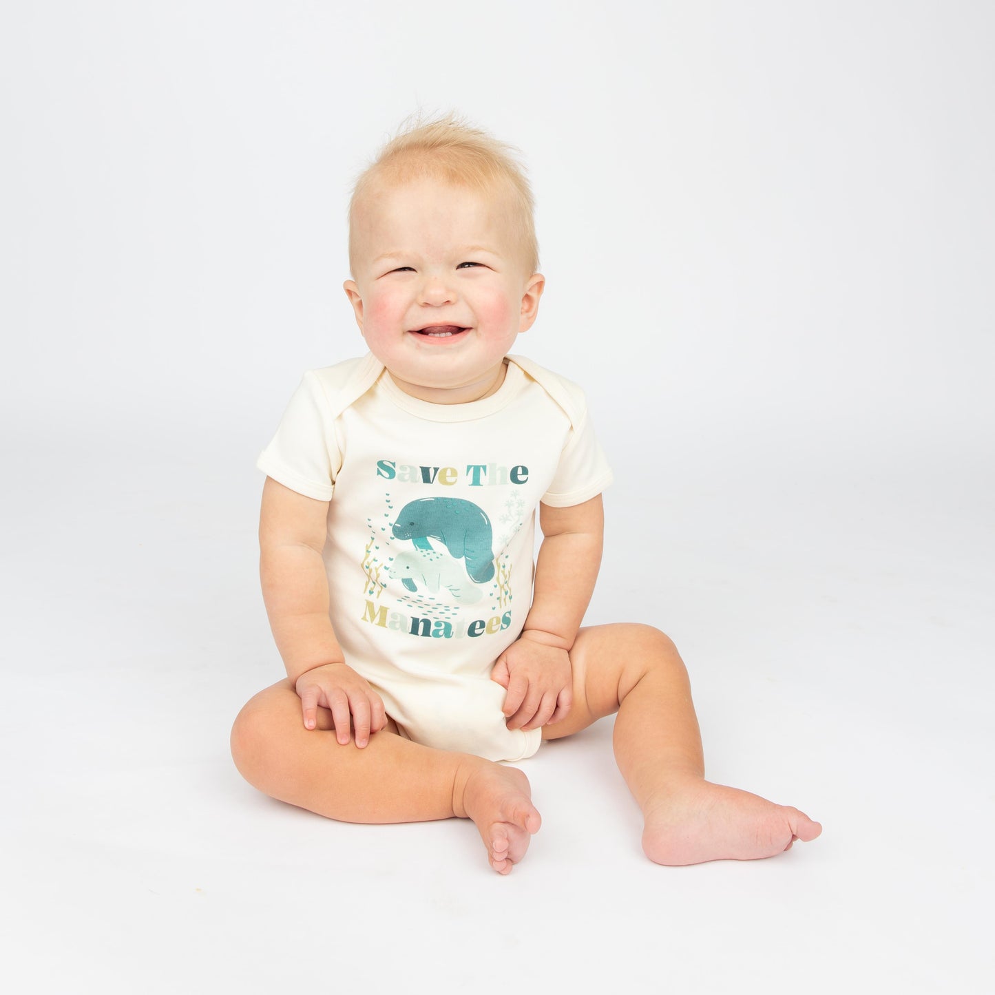 Baby wearing a Save the Manatees cotton bodysuit with a cute manatee print, featuring soft, eco-friendly fabric on a white background.