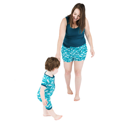 Woman and child wearing matching blue pajama sets with white patterns on a white background