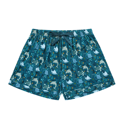 the "ocean friends" women's shorts. the "ocean friends" print is a combination of dolphins, stingrays, fish, starfish, coral, bubbles, and sharks, all spread out on a deep sea blue background. 