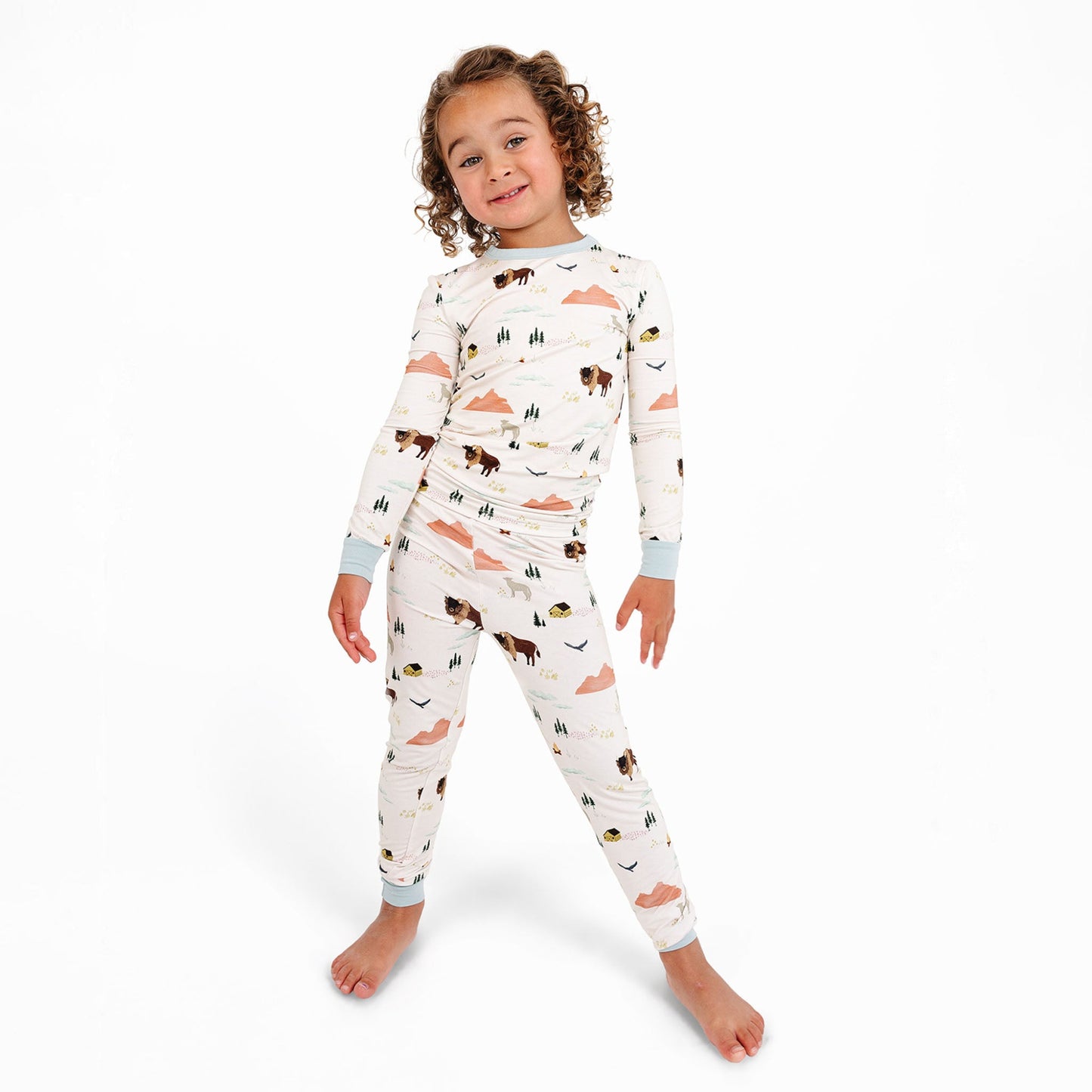 Child wearing a long-sleeve pajama set with animal pattern on a white background