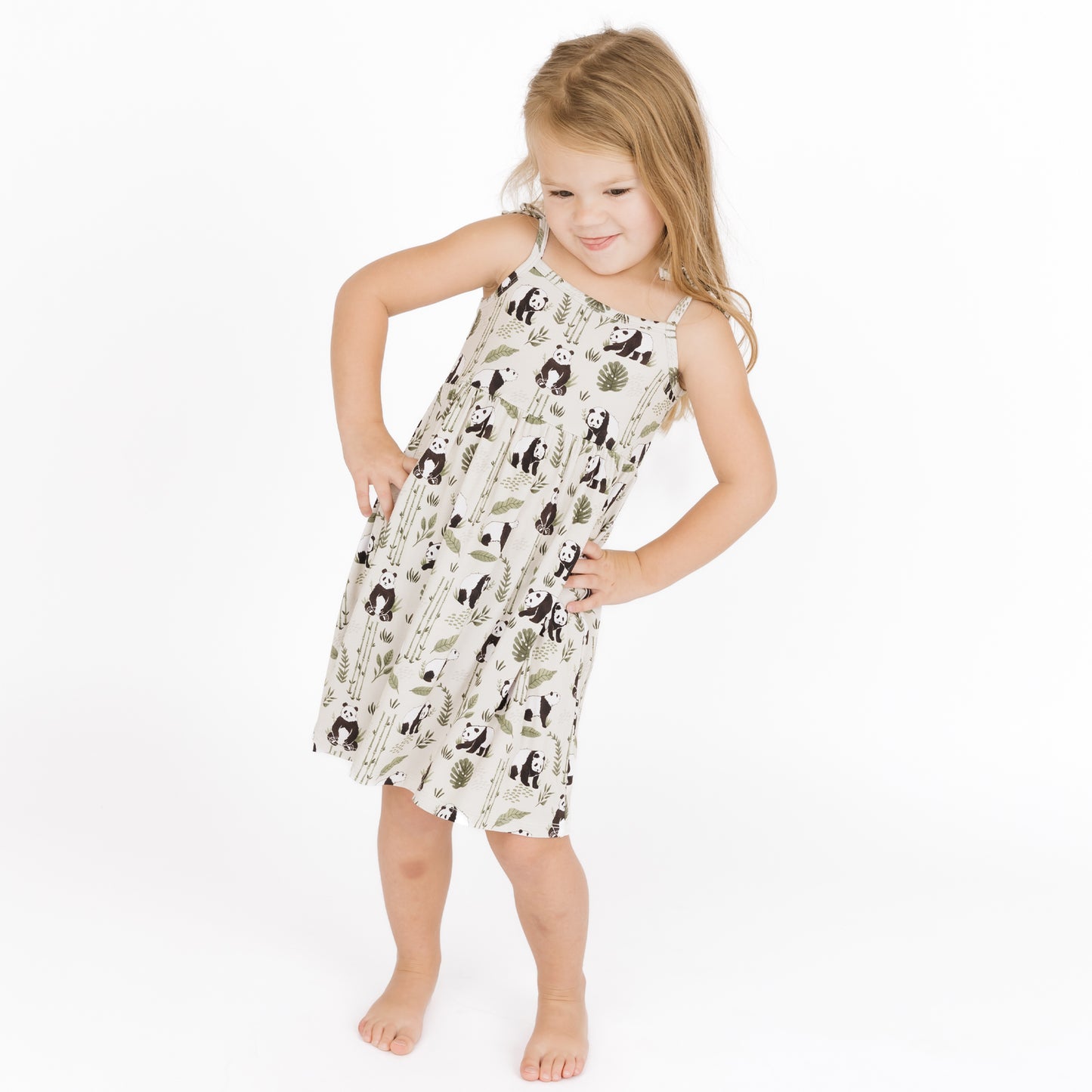 Young girl wearing a sleeveless dress with animal print on a white background