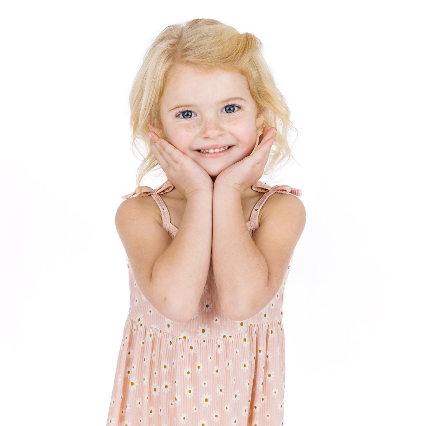 Young girl in a pink dress with daisy patterns on a white background