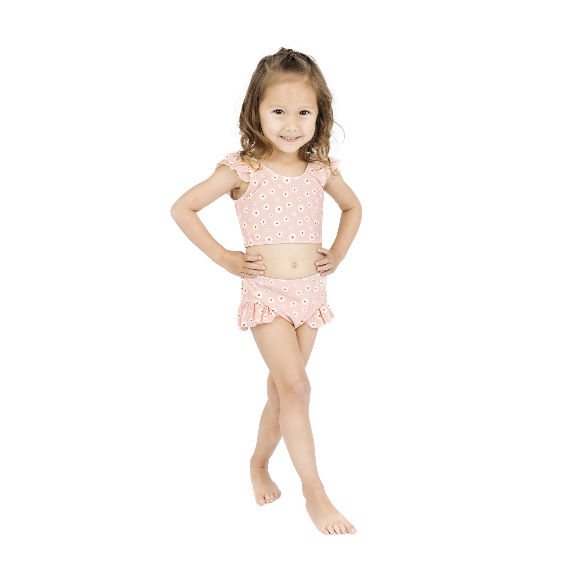 Young girl wearing a pink floral two-piece swimsuit on a white background
