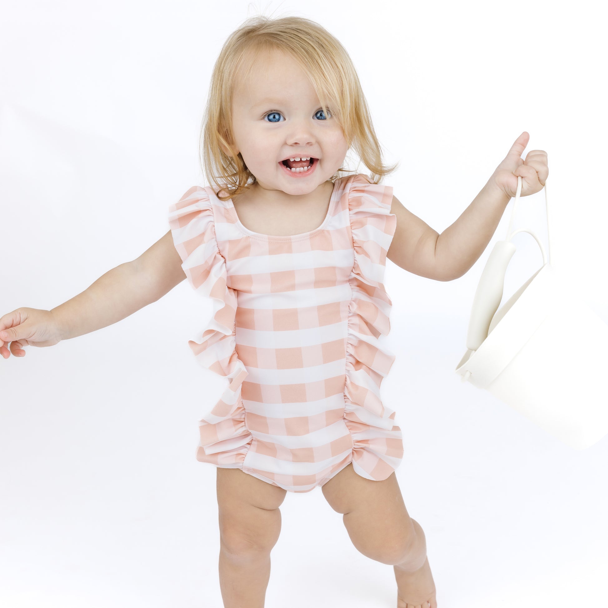 Child wearing a pink and white striped swimsuit on a white background
