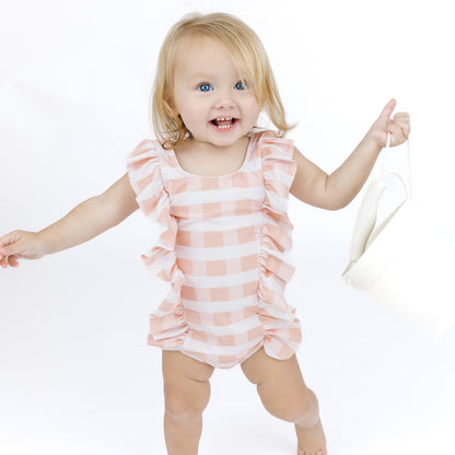 Child wearing a pink and white striped swimsuit on a white background