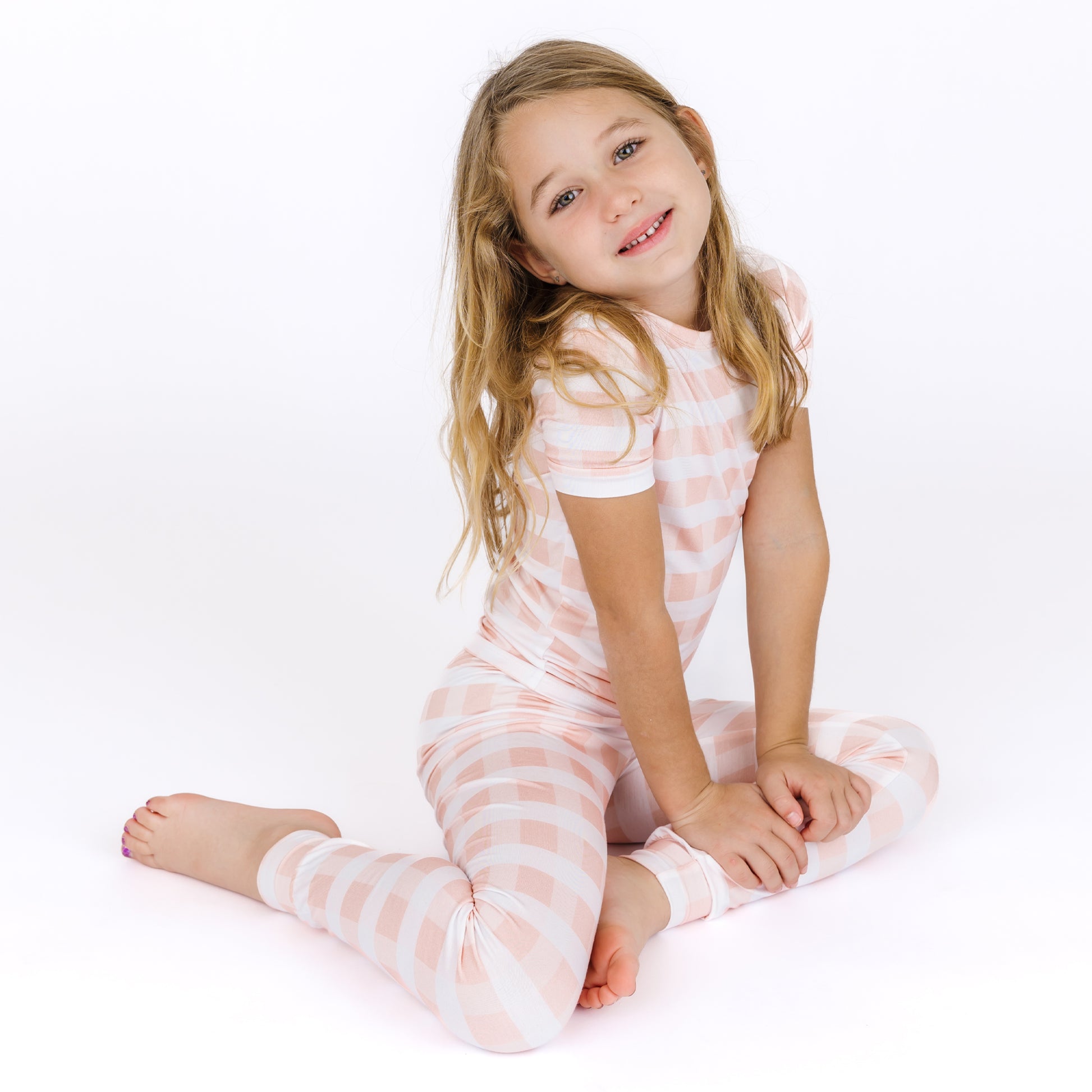 Young girl wearing a pink and white striped outfit on a white background