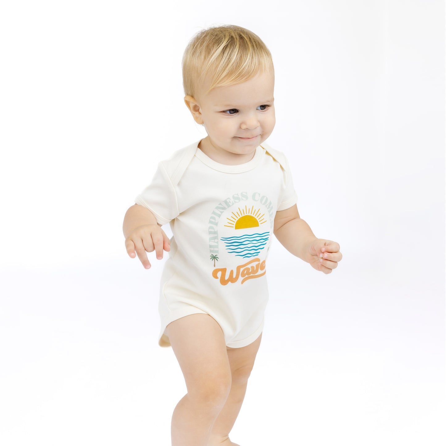 Baby wearing a white bodysuit with a beach graphic and text on a white background