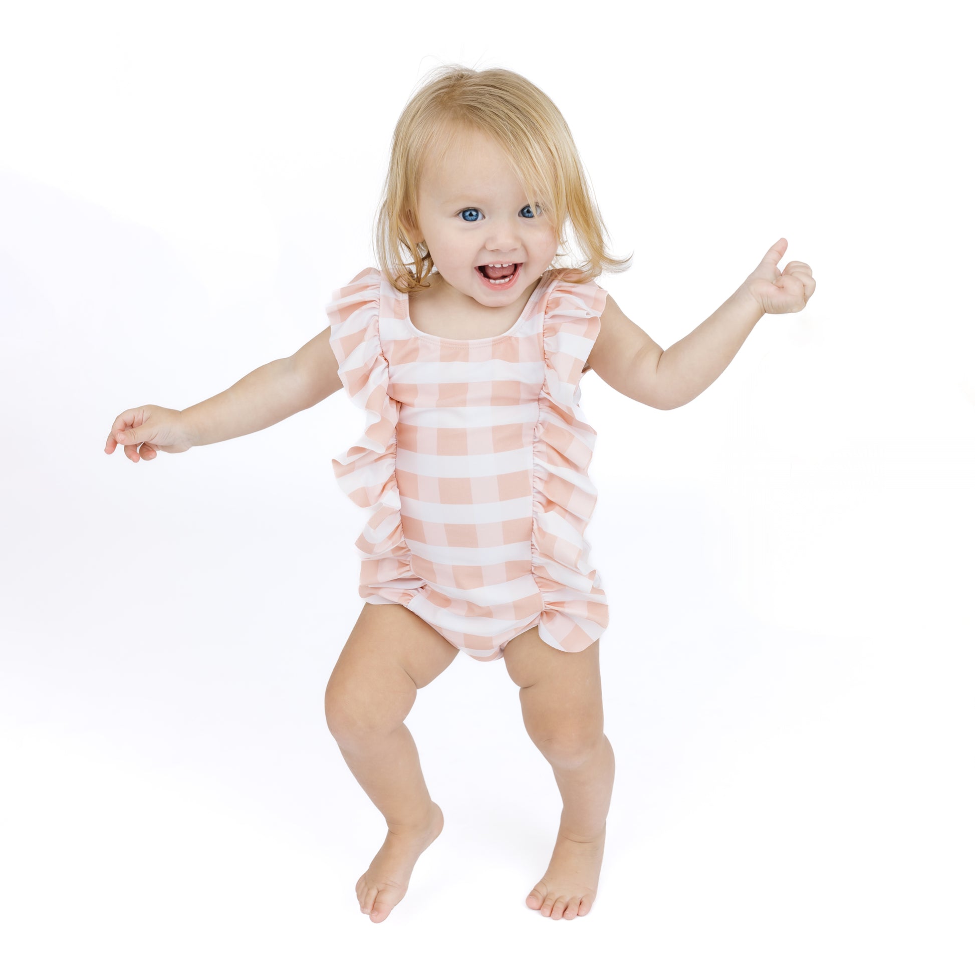 Child wearing a pink and white striped romper on a white background