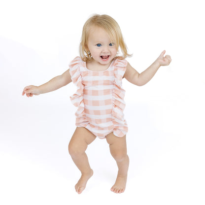 Child wearing a pink and white striped romper on a white background