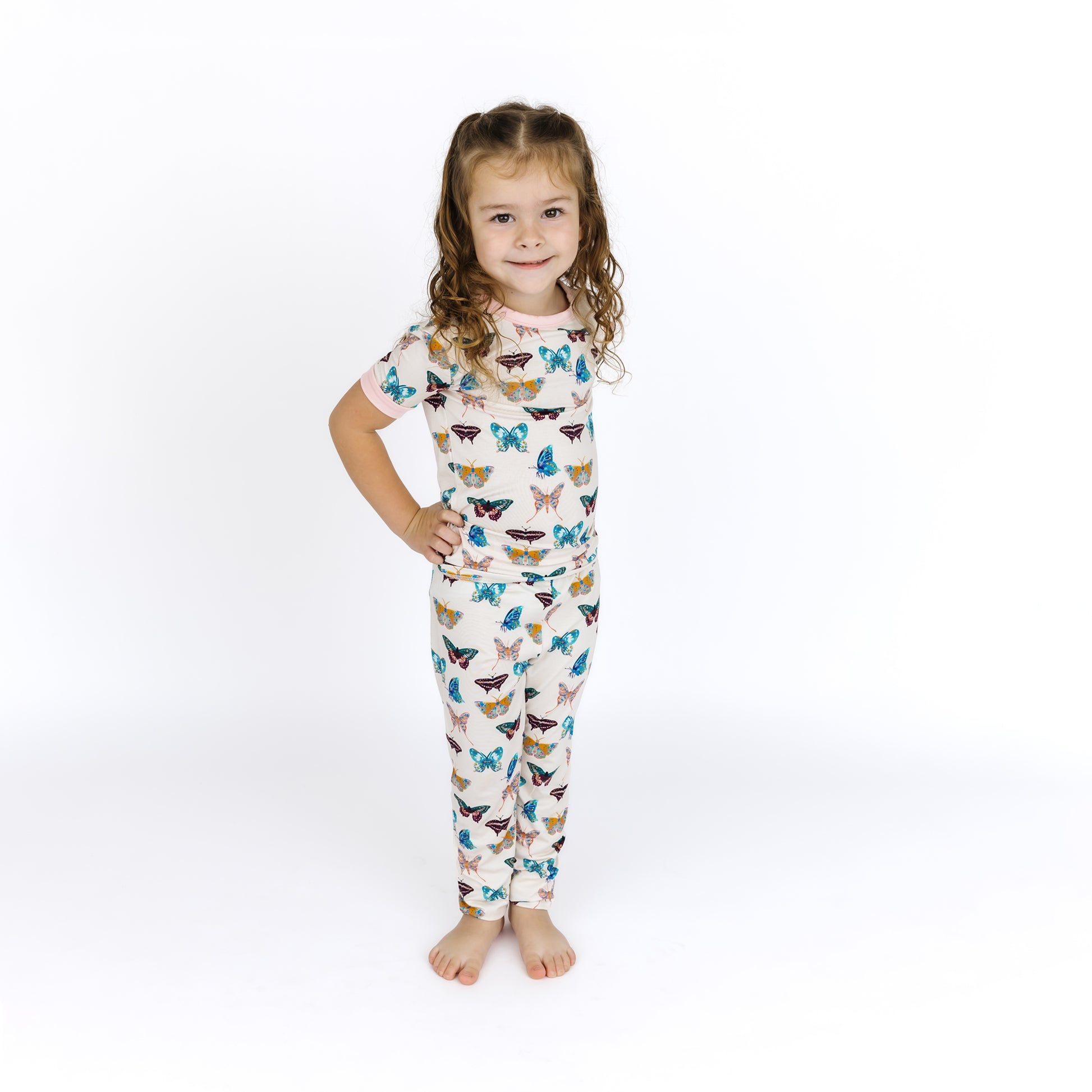 Smiling child modeling the buttery-soft Wings of Paradise butterfly bamboo pajama set.