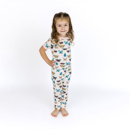 Smiling child modeling the buttery-soft Wings of Paradise butterfly bamboo pajama set.