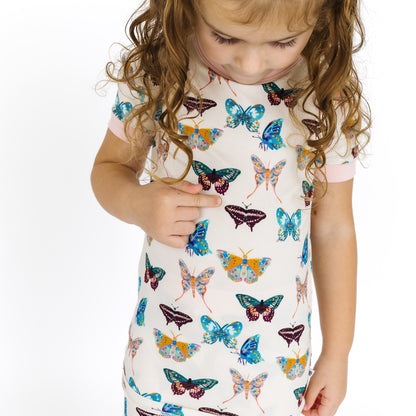 Close-up of the whimsical Wings of Paradise butterfly pattern featuring teal, purple, and gold hues.
