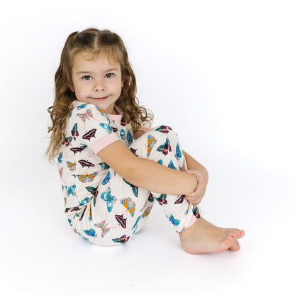 Young girl wearing the soft Wings of Paradise butterfly print bamboo pajamas for comfortable sleep.