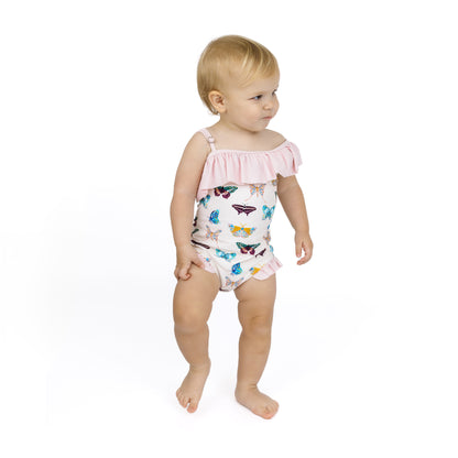 Child wearing a butterfly-patterned swimsuit on a white background