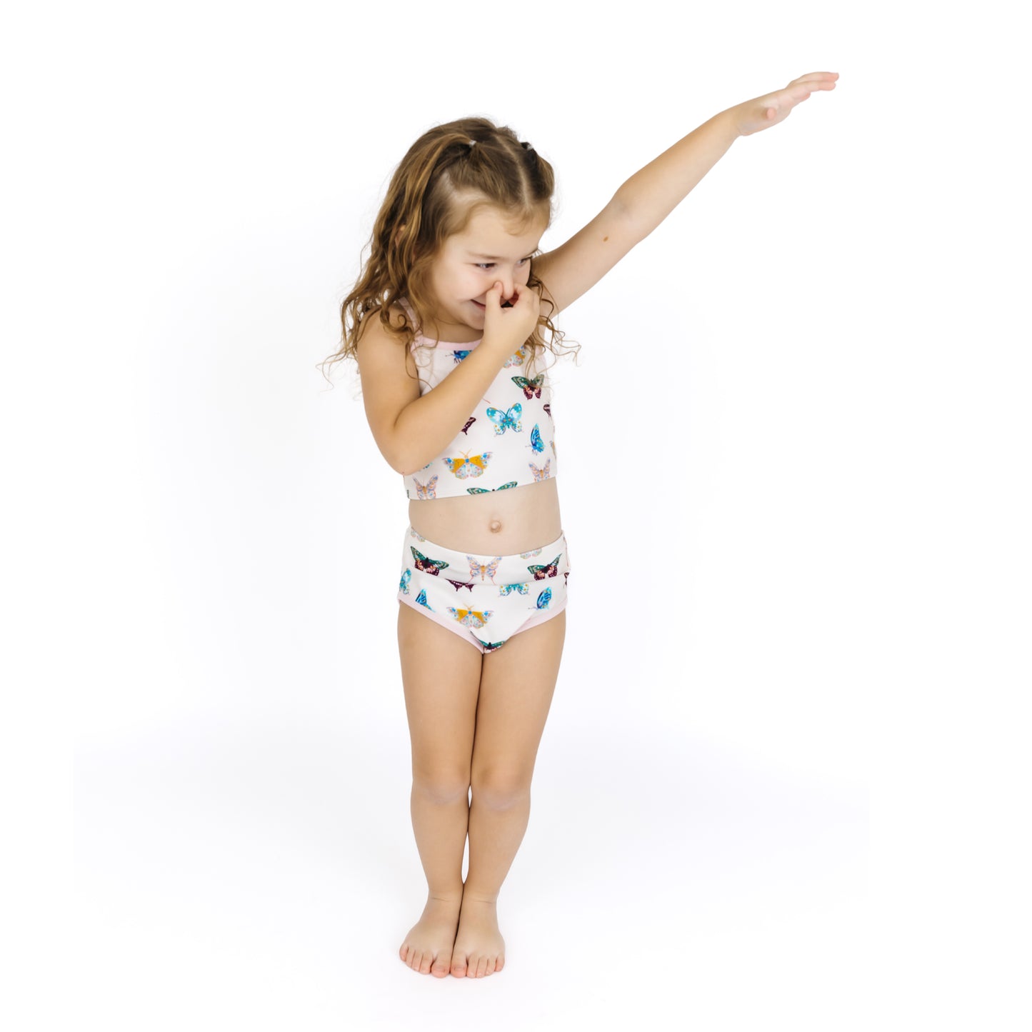 Young girl wearing a colorful butterfly-themed swimsuit on a white background