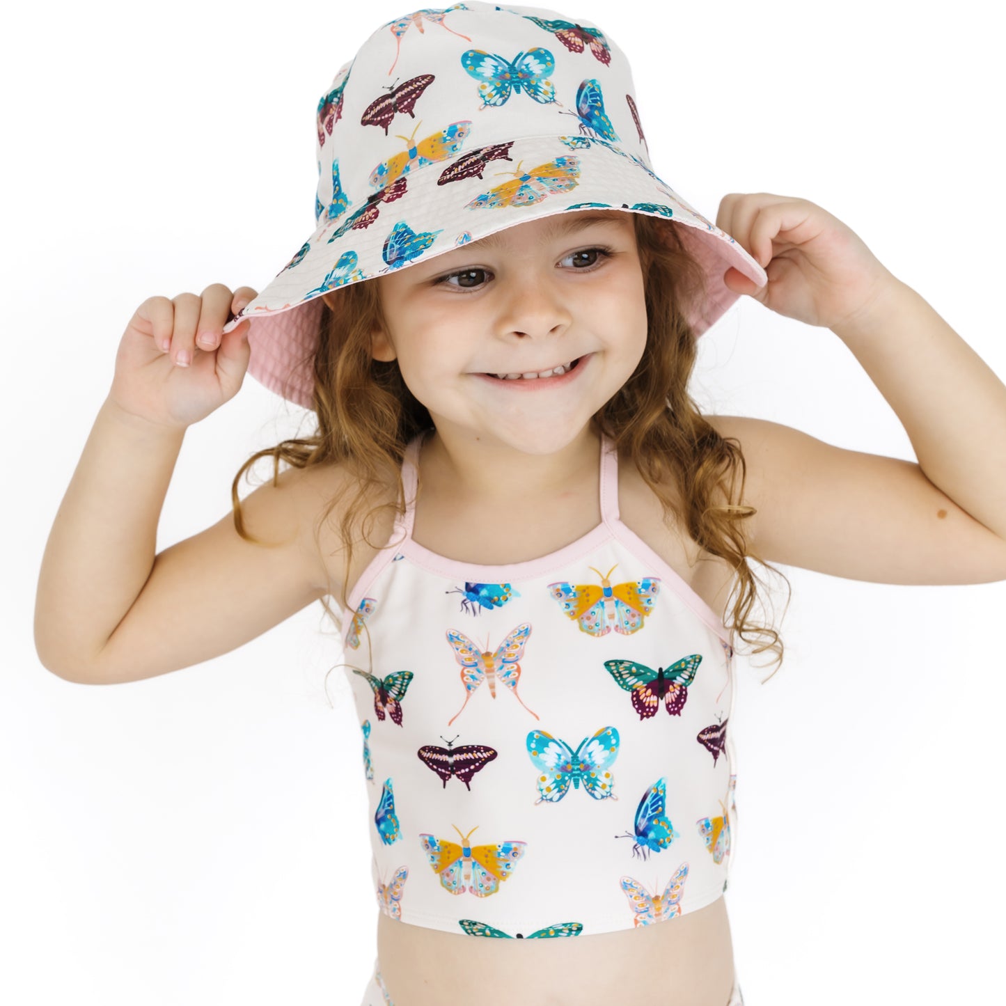 Child wearing a butterfly-patterned sun hat and swimsuit on a white background