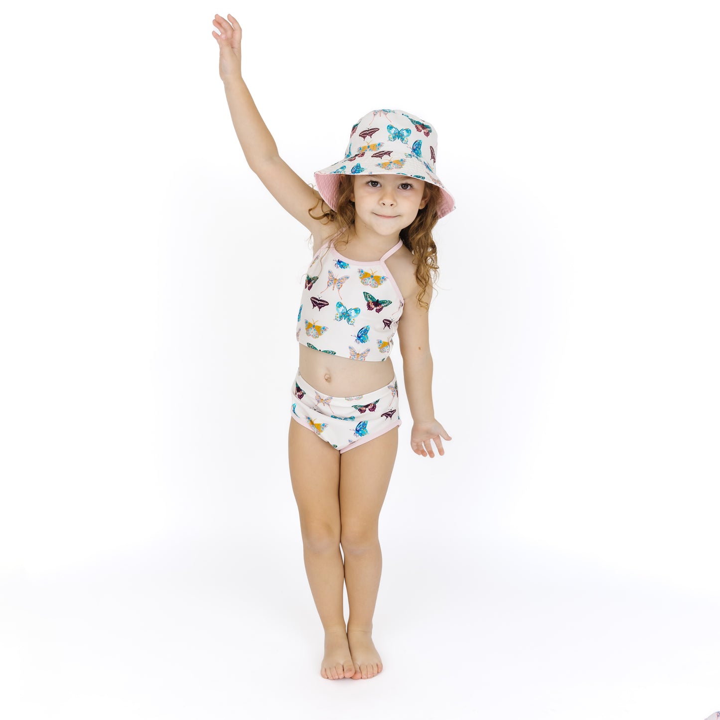 Child wearing a colorful butterfly-patterned swimsuit and hat on a white background